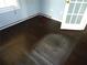 Corner room with dark hardwood floors, showing some wear, and a door to the exterior at 11511 Misty Isle Ln, Riverview, FL 33579