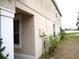 Side yard featuring manicured shrubs, a stucco wall, and views of the neighboring pond at 11511 Misty Isle Ln, Riverview, FL 33579