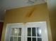 Stained wall above a white French door with glass panes, showing possible water damage at 11511 Misty Isle Ln, Riverview, FL 33579