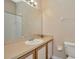 Well-lit bathroom featuring a large mirror, vanity, and toilet at 10429 Heron Lake Dr, Riverview, FL 33578