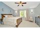 Spacious bedroom features a wooden bed, window, ceiling fan, and lamps at 10429 Heron Lake Dr, Riverview, FL 33578