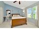 Inviting bedroom featuring wooden bed, vanity, mirror, and natural light at 10429 Heron Lake Dr, Riverview, FL 33578