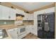 Kitchen with white cabinetry, black appliances, and wood-look flooring at 10429 Heron Lake Dr, Riverview, FL 33578