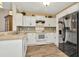Bright kitchen featuring white cabinets, black appliances, and wood floors at 10429 Heron Lake Dr, Riverview, FL 33578