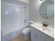 Clean bathroom with white fixtures, including a tub-shower combo, toilet, and vanity with a round mirror at 11114 Shadybrook Dr, Tampa, FL 33625