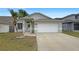 Charming single-Gathering home featuring a two-car garage, tidy lawn, and mature palm trees at 11114 Shadybrook Dr, Tampa, FL 33625