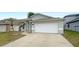 Charming single-Gathering home featuring a two-car garage, tidy lawn, and mature palm trees at 11114 Shadybrook Dr, Tampa, FL 33625