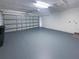 Spacious garage with a functional garage door, painted floor, and a pedestrian door at 11114 Shadybrook Dr, Tampa, FL 33625