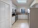 Well-lit kitchen features stainless steel appliances, white cabinets, and tile flooring for easy maintenance at 11114 Shadybrook Dr, Tampa, FL 33625