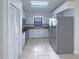 Well-lit kitchen features stainless steel appliances, white cabinets, and tile flooring for easy maintenance at 11114 Shadybrook Dr, Tampa, FL 33625