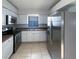 Well-lit kitchen featuring stainless steel appliances, white cabinets, and tile flooring at 11114 Shadybrook Dr, Tampa, FL 33625