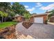 Inviting brick home with a landscaped front yard, brick driveway, and a two-car garage at 307 N Glen Ave, Tampa, FL 33609