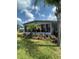 Charming home featuring a well-manicured lawn and beautiful landscaping with lush tropical plants and colorful flowerbeds at 5258 Wisteria Cir, New Port Richey, FL 34653
