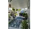 Covered patio is decorated with comfortable seating, lush plants, and a stylish rug, creating a welcoming outdoor living space at 5258 Wisteria Cir, New Port Richey, FL 34653