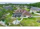 Aerial view of home, showcasing a screened pool, fire pit, manicured yard, and white perimeter fencing at 27740 Water Ash Dr, Wesley Chapel, FL 33544