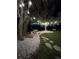 Tranquil backyard setting with shaded seating area, lush lawn, and ambient string lighting at 27740 Water Ash Dr, Wesley Chapel, FL 33544