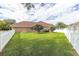 Expansive backyard featuring lush lawn, white picket fence, and mature trees, perfect for outdoor activities at 27740 Water Ash Dr, Wesley Chapel, FL 33544