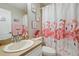 Bright bathroom with a flamingo-themed shower curtain, vanity, and framed artwork, offering a whimsical design at 27740 Water Ash Dr, Wesley Chapel, FL 33544