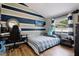 Bedroom with blue and gray stripe accent wall, complete with a desk and gaming chair at 27740 Water Ash Dr, Wesley Chapel, FL 33544