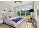 Bright bedroom with hardwood floors, lake view, and large windows at 27740 Water Ash Dr, Wesley Chapel, FL 33544