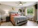 Well-lit bedroom featuring a view of a lake, wooden floors and neutral decor at 27740 Water Ash Dr, Wesley Chapel, FL 33544