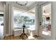 Bright breakfast nook with white cushioned seating and a view of the screened-in pool and outdoor kitchen at 27740 Water Ash Dr, Wesley Chapel, FL 33544