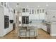 Bright kitchen featuring white cabinets, granite countertops, stainless steel appliances, and an island with bar seating at 27740 Water Ash Dr, Wesley Chapel, FL 33544