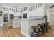 Modern kitchen boasts white cabinets, granite countertops, stainless steel appliances, and wood flooring at 27740 Water Ash Dr, Wesley Chapel, FL 33544