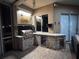 Outdoor kitchen with stainless steel grill, built-in fridge, and granite countertops at 27740 Water Ash Dr, Wesley Chapel, FL 33544