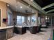 Spacious covered patio featuring ample seating, a bar area, and serene views of the backyard and pool at 27740 Water Ash Dr, Wesley Chapel, FL 33544