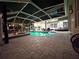 Paver patio with view of pool and hot tub with string lights at 27740 Water Ash Dr, Wesley Chapel, FL 33544