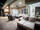 Spacious covered patio with comfortable seating, ceiling fans, and an outdoor kitchen at 27740 Water Ash Dr, Wesley Chapel, FL 33544