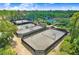 Aerial view of several well-maintained community tennis courts surrounded by lush landscaping and mature trees at 27740 Water Ash Dr, Wesley Chapel, FL 33544