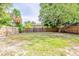 Large backyard with grass, trees, and a wooden fence provides privacy and space at 4226 E Emma St, Tampa, FL 33610