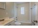 Bathroom featuring a tub with a glass block window, vanity, and fixtures at 4226 E Emma St, Tampa, FL 33610