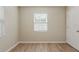 A sunny bedroom features wood-look flooring and a window providing ample natural light at 4226 E Emma St, Tampa, FL 33610