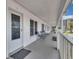 Exterior walkway featuring a seating area, a door, and views of the surrounding complex and landscaping at 680 71St Ave # 9, St Pete Beach, FL 33706