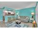 Bright living room with turquoise walls, bar seating to kitchen, and coastal-themed decor at 680 71St Ave # 9, St Pete Beach, FL 33706