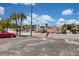Exterior view of a parking lot with visible parking spaces against a sunny, partly cloudy sky at 680 71St Ave # 9, St Pete Beach, FL 33706