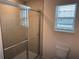 Bathroom featuring a glass shower enclosure with tile walls and a window at 32122 Eastern Redbud Br, San Antonio, FL 33576