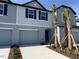 Charming exterior elevation of a two-story townhome with blue shutters and landscaping at 32122 Eastern Redbud Br, San Antonio, FL 33576
