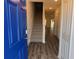 Bright entryway featuring a vibrant blue front door, wood-look floors, and a staircase at 32128 Eastern Redbud Br, San Antonio, FL 33576