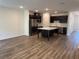 Spacious kitchen with stainless steel appliances, island, and dark cabinets, seamlessly flowing into the living area at 32128 Eastern Redbud Br, San Antonio, FL 33576