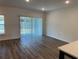 Bright and airy living area with wood-look floors and a sliding glass door at 32128 Eastern Redbud Br, San Antonio, FL 33576