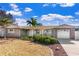 Charming home featuring a stone facade, well-manicured landscaping, and a quaint, inviting front yard at 5511 1St Avenue Nw Dr, Bradenton, FL 34209