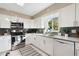 Modern kitchen featuring white cabinets, stainless steel appliances, and a window with a pleasant view at 5511 1St Avenue Nw Dr, Bradenton, FL 34209