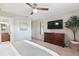 Bedroom featuring a king-size bed, dresser with TV, a ceiling fan and an en-suite bath at 5511 1St Avenue Nw Dr, Bradenton, FL 34209