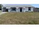 Welcoming one-story home featuring an attached carport, contrasting front door, and a spacious grassy front yard at 821 Silver Springs Nw Ter, Port Charlotte, FL 33948