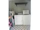 This laundry room features a washer, dryer, water heater and shelving at 821 Silver Springs Nw Ter, Port Charlotte, FL 33948