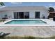 Backyard pool with white surround, showcasing the house with sliding doors for easy indoor-outdoor living at 821 Silver Springs Nw Ter, Port Charlotte, FL 33948
